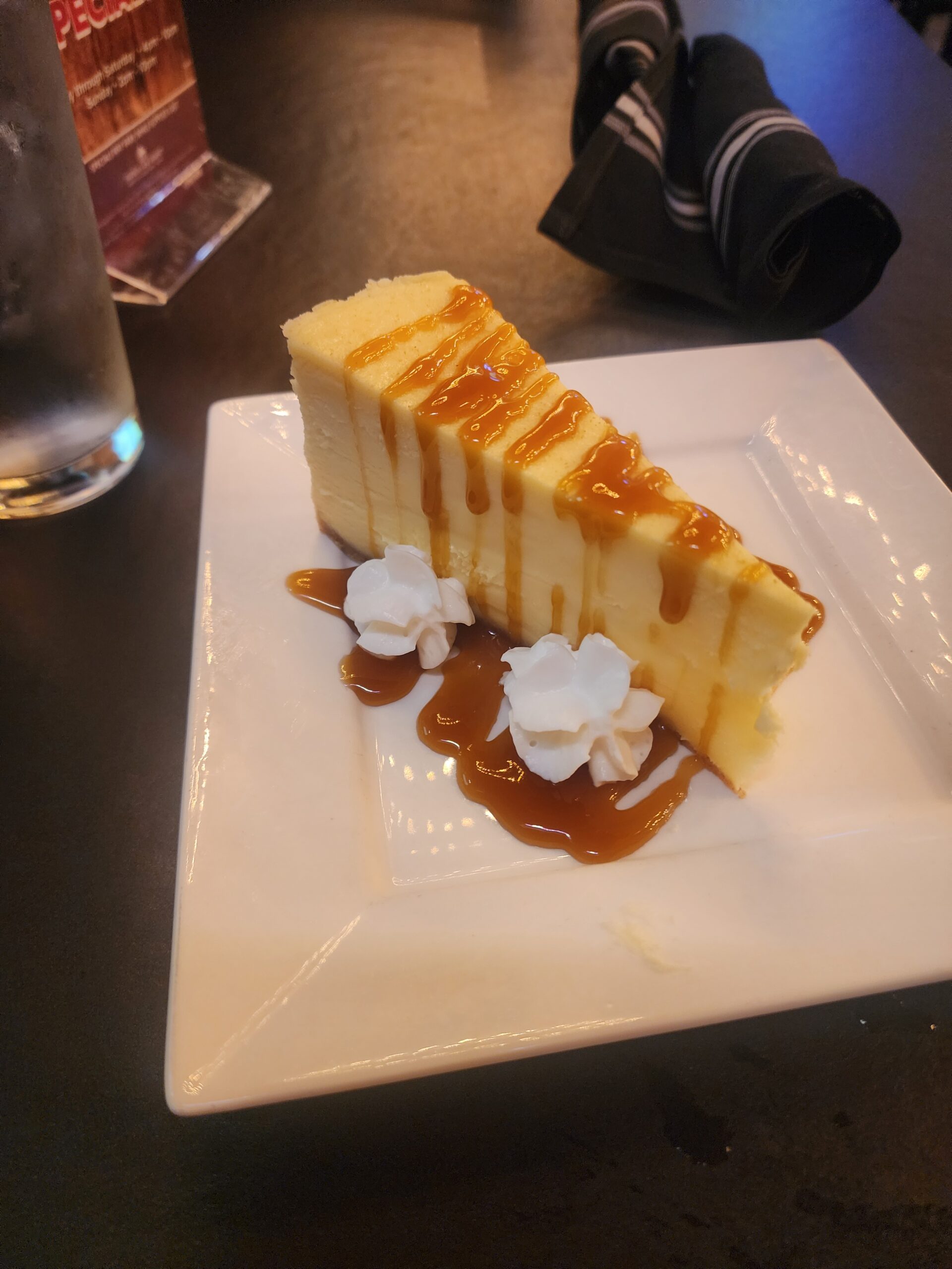 A piece of caramel cheesecake on a white plate